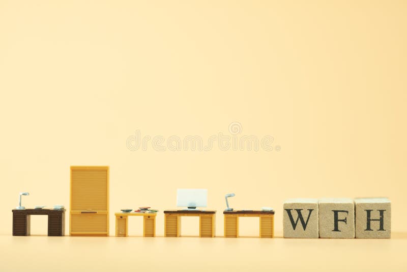 Miniature office table with wood block text of WFH