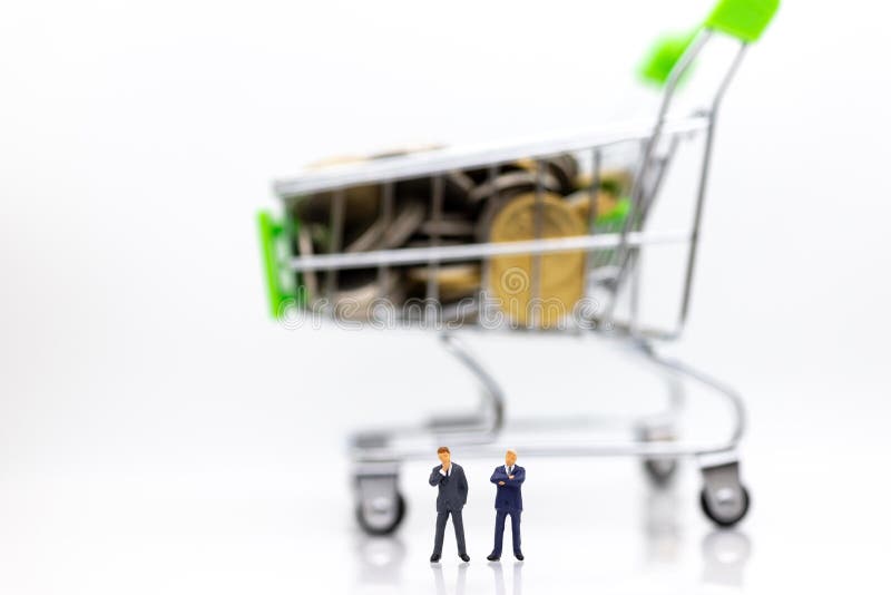 Miniature people : Businessman standing with shopping cart on stack of coin. Image use for retail business concept royalty free stock photos