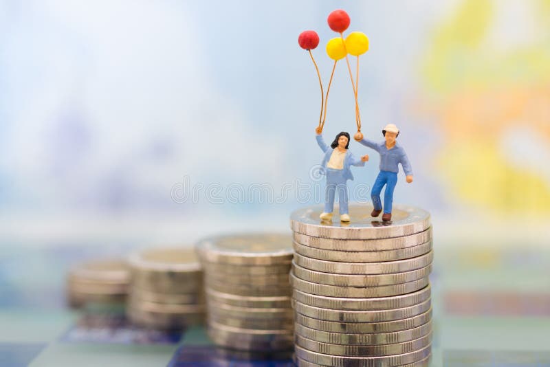 Miniature people : Children standing on stack of coins with balloon. Image use for Health insurance for children, business concept royalty free stock images Miniature people : Children standing on stack of coins with balloon. Image use for Health insurance for children, business concept royalty free stock images