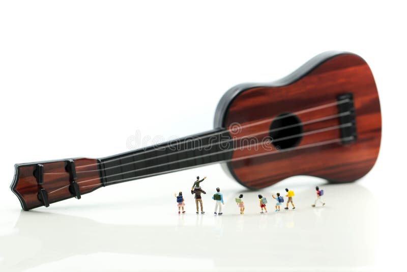 Miniature people : children and student with acoustic guitar,time of relax or music relax,stationary,education concept. stock photos Miniature people : children and student with acoustic guitar,time of relax or music relax,stationary,education concept. stock photos