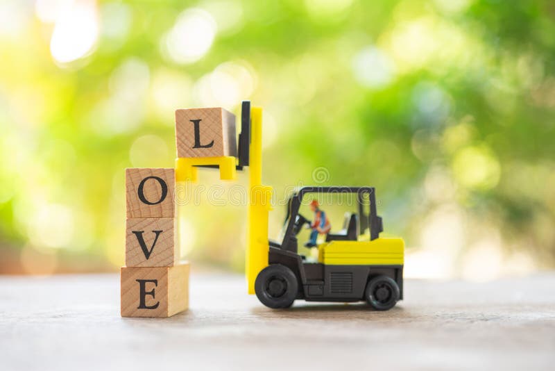 Miniature people Construction worker with wood word LOVE. Day 14 meets Valentine Day. using as background Valentine concept with