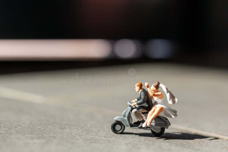 Miniature people : Couple in love riding a motorbike , Adventure and vacations concept