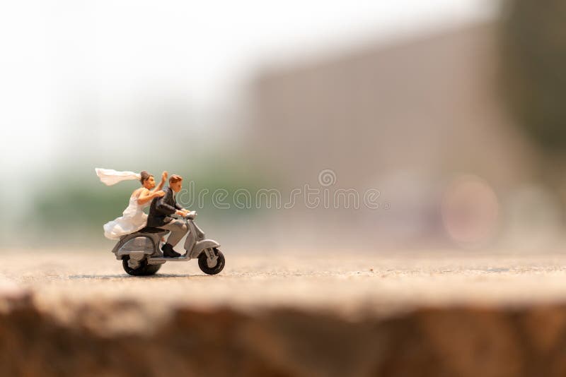 Miniature people : Couple riding the motorcycle in the garden  , Valentine`s Day concept