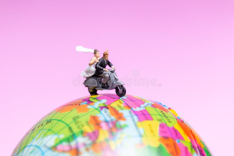 Miniature people : Couple riding the motorcycle on The Globe , Valentines concept