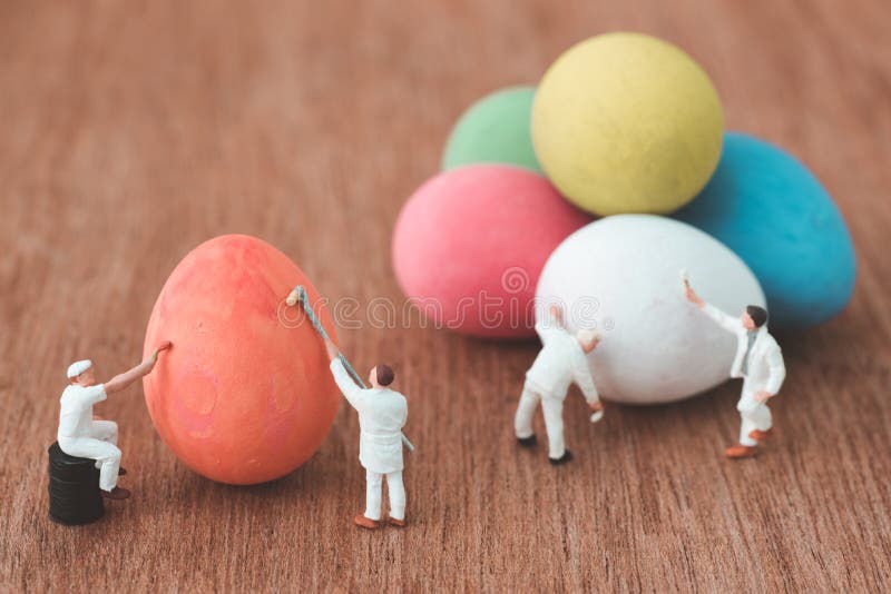 Miniature people painting easter eggs stock photo Miniature people painting easter eggs stock photo