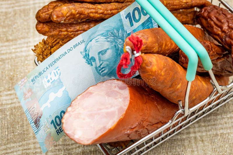 A miniature shopping cart full of all kinds of cold cuts with a Brazilian 100 Reais banknote, Concept, Rising prices of meat