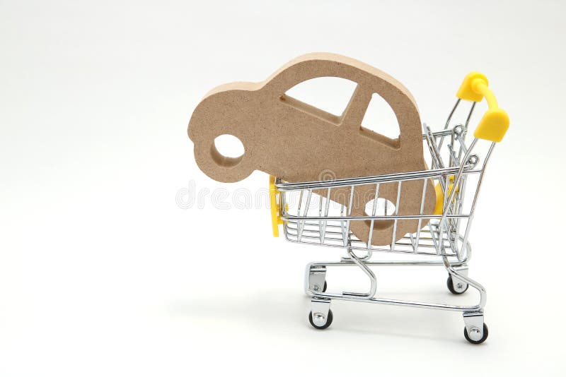 Miniature wooden car and shopping cart on white background. Concept of buying new car. royalty free stock image Miniature wooden car and shopping cart on white background. Concept of buying new car. royalty free stock image