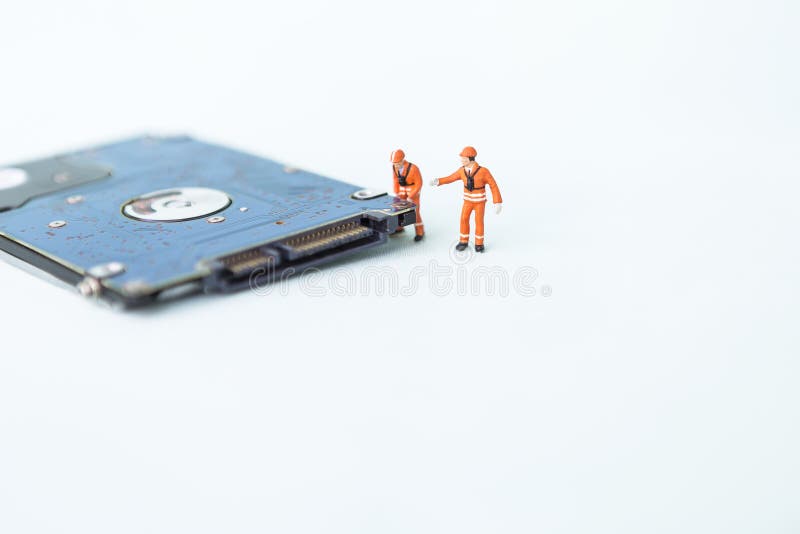 Miniature worker with hard disk on white background, computer service and maintenance business concept