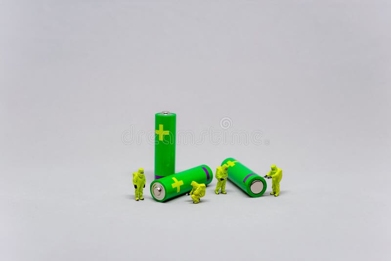 Miniature workers with green batteries concept stock image