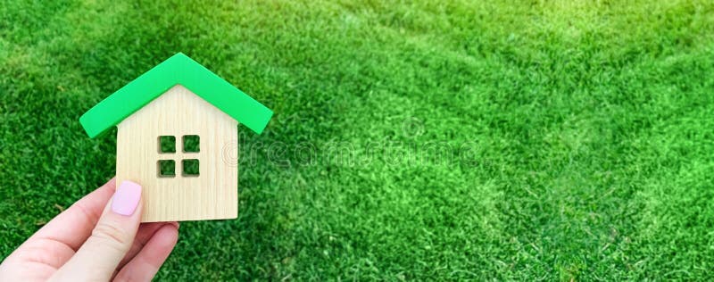 Miniature wooden house on green grass. Real estate concept. Eco-friendly and energy efficient house. Buying a home outside the city. The urban downshift. Nature. Fresh air. Mortgage, loan. Property. Miniature wooden house on green grass. Real estate concept. Eco-friendly and energy efficient house. Buying a home outside the city. The urban downshift. Nature. Fresh air. Mortgage, loan. Property