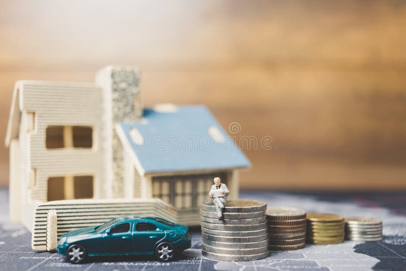 Miniaturleute, die mit Münzengeld mit Haus sitzen lizenzfreies stockfoto Miniaturleute, die mit Münzengeld mit Haus sitzen lizenzfreies stockfoto
