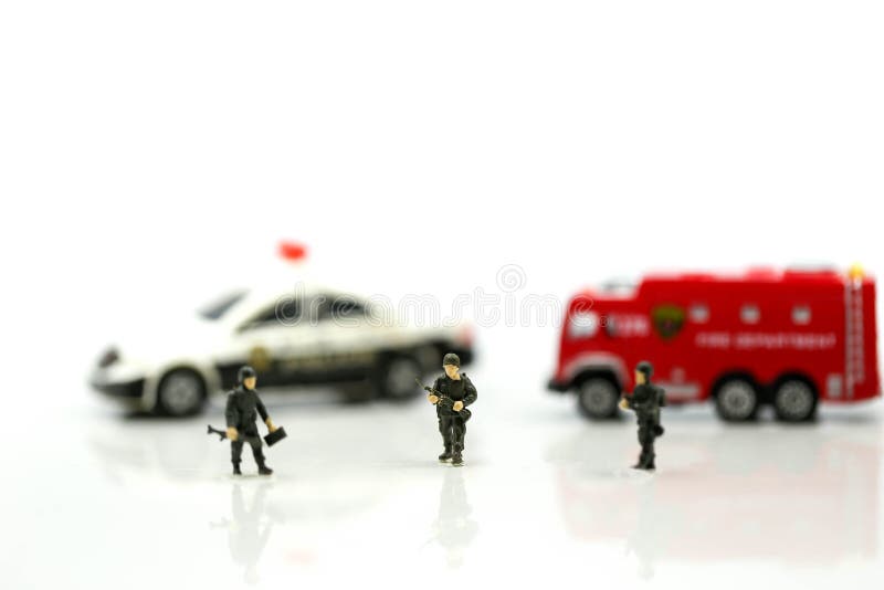 Miniaturleute: Soldatteam mit Löschfahrzeug und Polizeiwagen lizenzfreie stockfotografie Miniaturleute: Soldatteam mit Löschfahrzeug und Polizeiwagen lizenzfreie stockfotografie