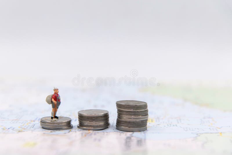 Miniaturmann ziehen sich den Reisenden zurück, der auf in den Einsparungens-Münzen für Reise auf der ganzen Welt wachsen steht Wa stockfoto