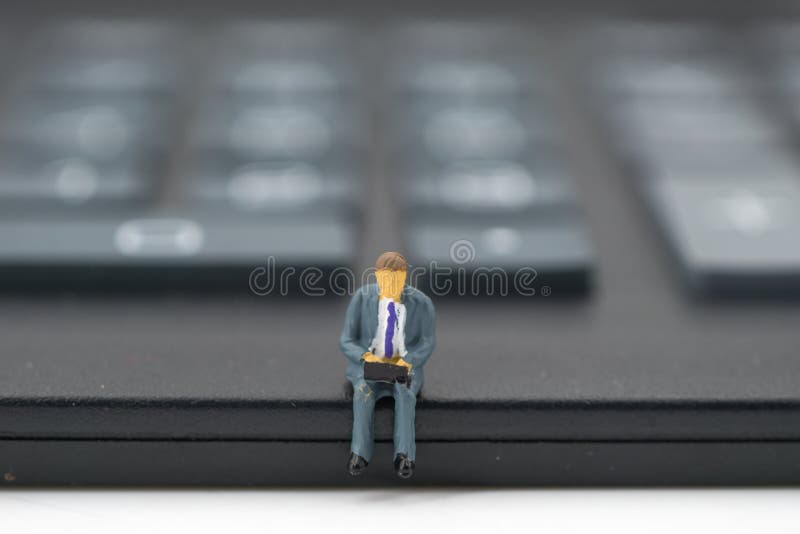 Miniaturowi ludzie: biznesmena obsiadanie na kalkulatorze obraz stock Miniaturowi ludzie: biznesmena obsiadanie na kalkulatorze obraz stock