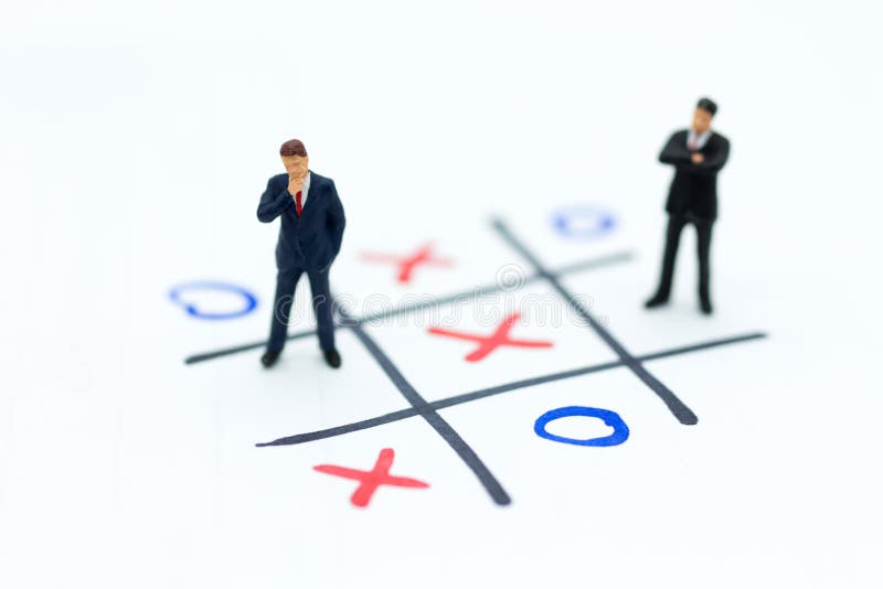Miniaturowi ludzie: Biznesmeni stoją na XO gry desce Wizerunku use dla biznesowego turniejowego pojęcia