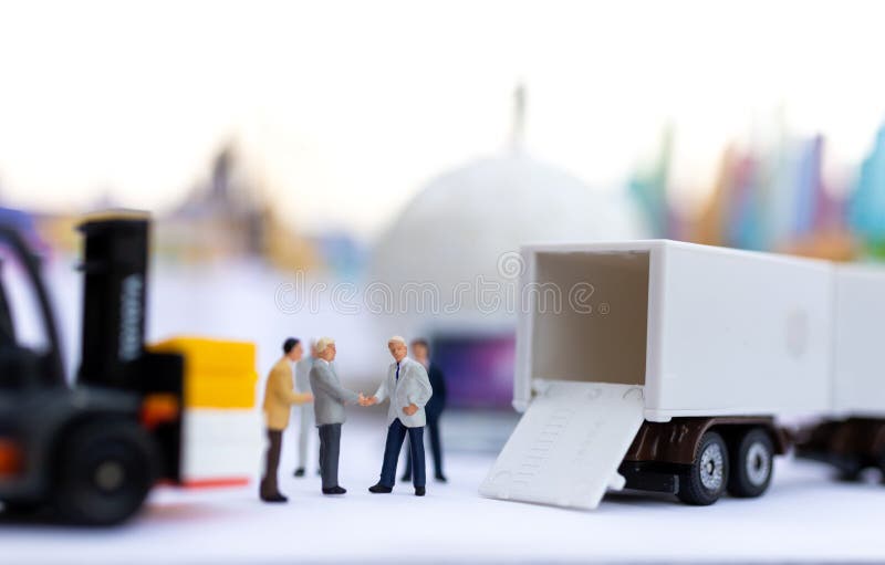 Miniaturowi ludzie : biznesmeni trzymają się za ręce, by razem robić interesy. wykorzystanie obrazu dla logistycznych pojęć ładunku wysyłkowego.
