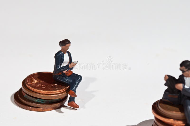 Miniaturowi ludzie siedzi na monetach zdjęcie royalty free