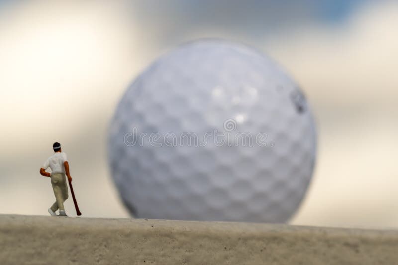 Miniatuurgolfspeler en Reus Vage Golfball royalty-vrije stock foto Miniatuurgolfspeler en Reus Vage Golfball royalty-vrije stock foto