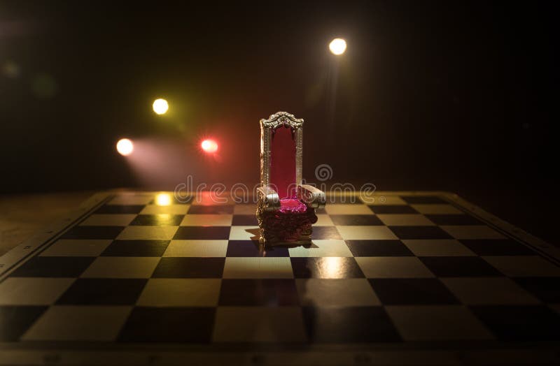 Minifotoliu regal roșu pe masă din lemn. tronul medieval de pe tabla de șah. conceptul de joc de șah, idei de afaceri și stock photography