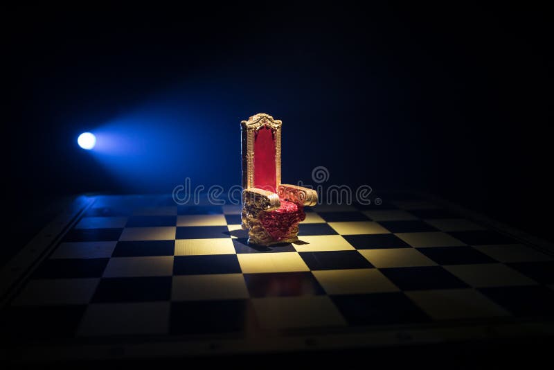 Minifotoliu regal roșu pe masă din lemn. tronul medieval de pe tabla de șah. conceptul de joc de șah, idei de afaceri și royalty free stock photo