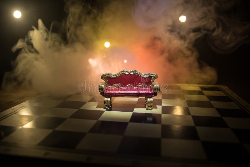 Minifotoliu regal roșu pe masă din lemn. tronul medieval de pe tabla de șah. conceptul de joc de șah, idei de afaceri și stock photography