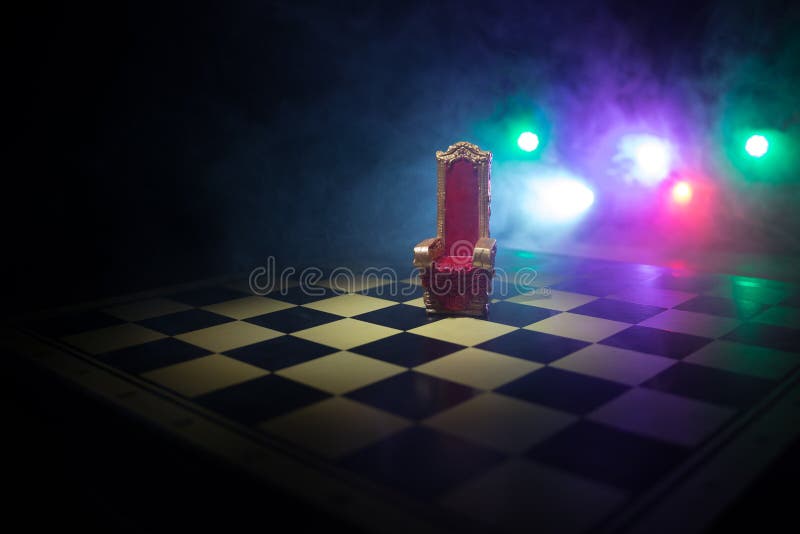 Minifotoliu regal roșu pe masă din lemn. tronul medieval de pe tabla de șah. conceptul de joc de șah, idei de afaceri și royalty free stock photos