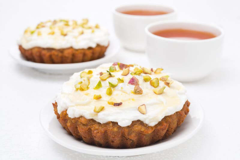 Minikarottenkuchen mit mascarpone, Honig, Pistazien, schwarzer Tee stockbild Minikarottenkuchen mit mascarpone, Honig, Pistazien, schwarzer Tee stockbild