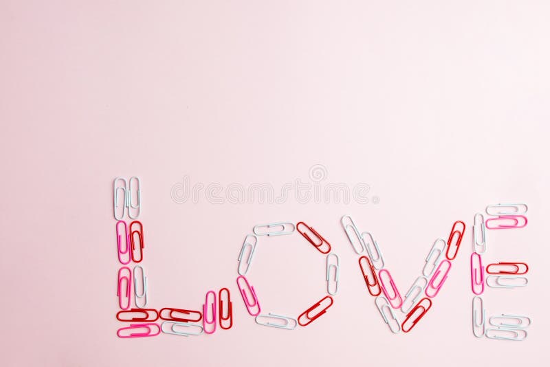 Minimaal concept Word ` liefde ` van kantoorbehoeftenklemmen wordt gemaakt op roze achtergrond die Vlak leg, hoogste mening stock foto's Minimaal concept Word ` liefde ` van kantoorbehoeftenklemmen wordt gemaakt op roze achtergrond die Vlak leg, hoogste mening stock foto's