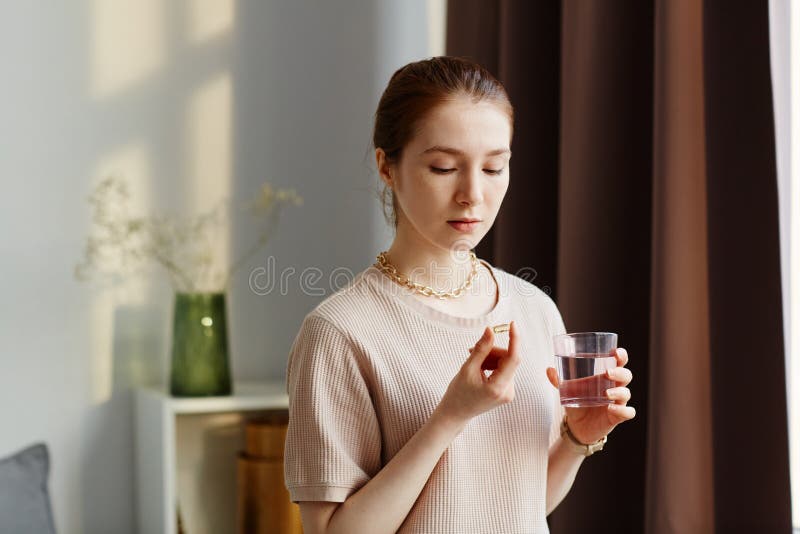 Young Woman Taking Vitamin Supplements