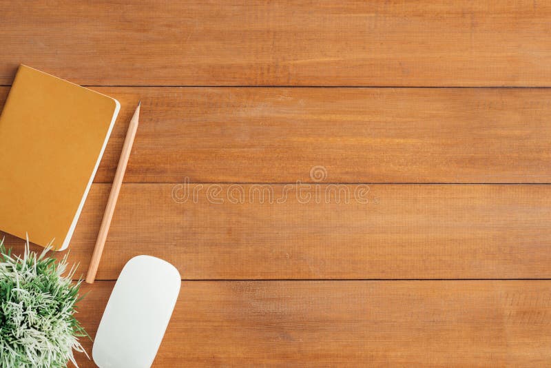 Office desk wooden table background with mock up notebooks and pencil and plant.