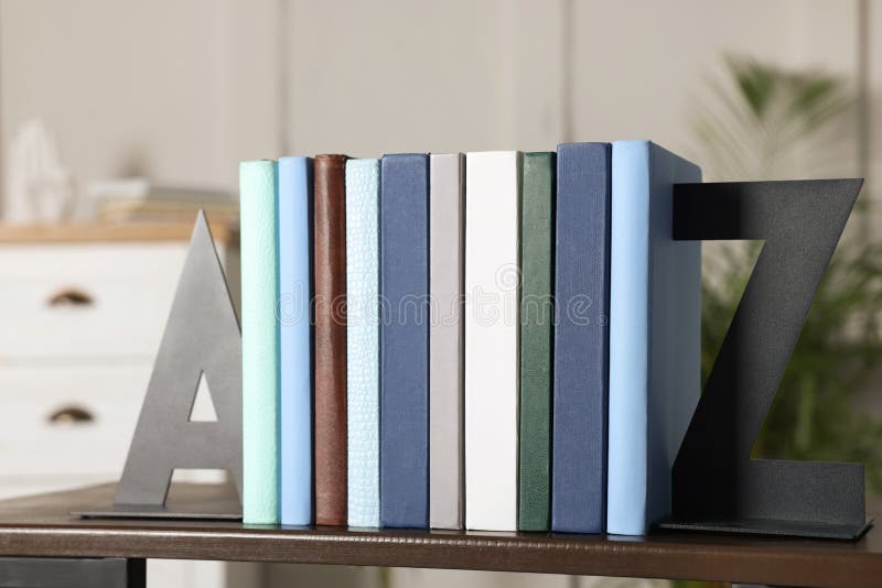 Minimalist letter bookends with books on shelf indoors