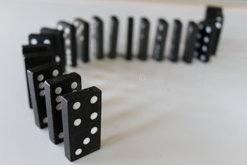 Abstract dominoes lined up on white background metaphor for cause and effect, fate, insurance, causality, fallen, chain royalty free stock image