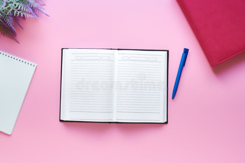 Minimalistic desktop - diary, pen, notebook for notes, flat lay on a pink background. home workspace concept