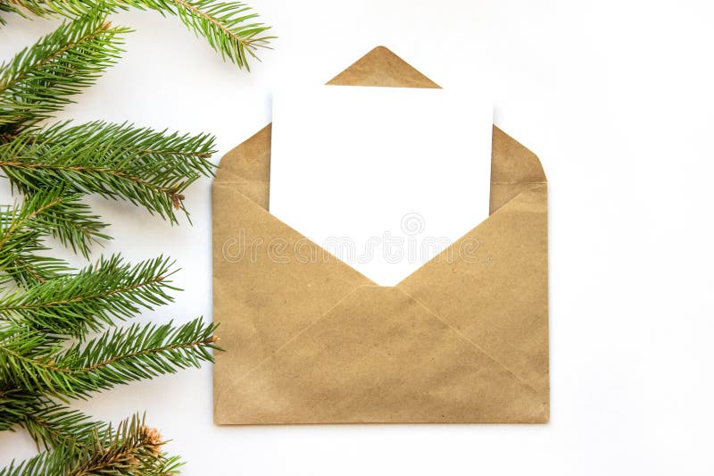 Minimalistic postcard layout with spruce branch. Kraft envelope, flat lay, top view close up. royalty free stock photography