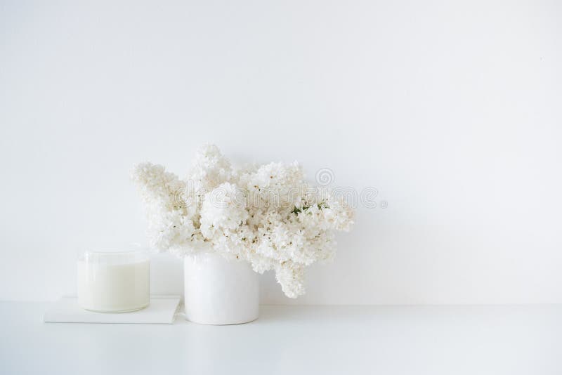 Minimalistisch wit huisdecor, vers lilac bloemenboeket in vaas