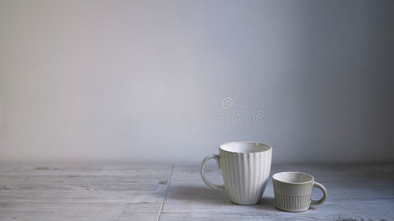 Minimalistic Scandinavian style. Two cups of coffee or tea of different sizes for two on on the table. Empty space. Wide frame. Minimalistic Scandinavian style. Two cups of coffee or tea of different sizes for two on on the table. Empty space. Wide frame