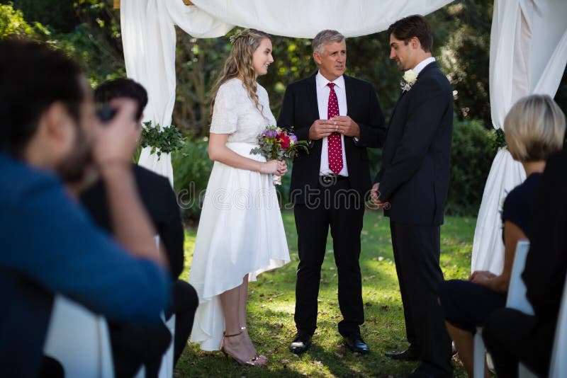 Minister giving speech to bride and groom