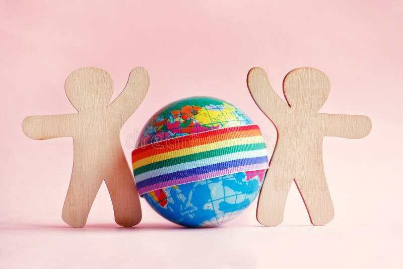 Ministuk speelgoed houten silhouetten van mensen en bol met regenbooglgbt lint op roze achtergrond royalty-vrije stock foto's Ministuk speelgoed houten silhouetten van mensen en bol met regenbooglgbt lint op roze achtergrond royalty-vrije stock foto's