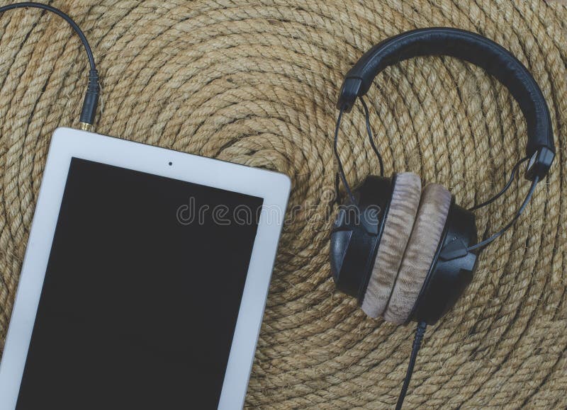 Minnestavla- och headphonemusik på jute rope bakgrund arkivfoton