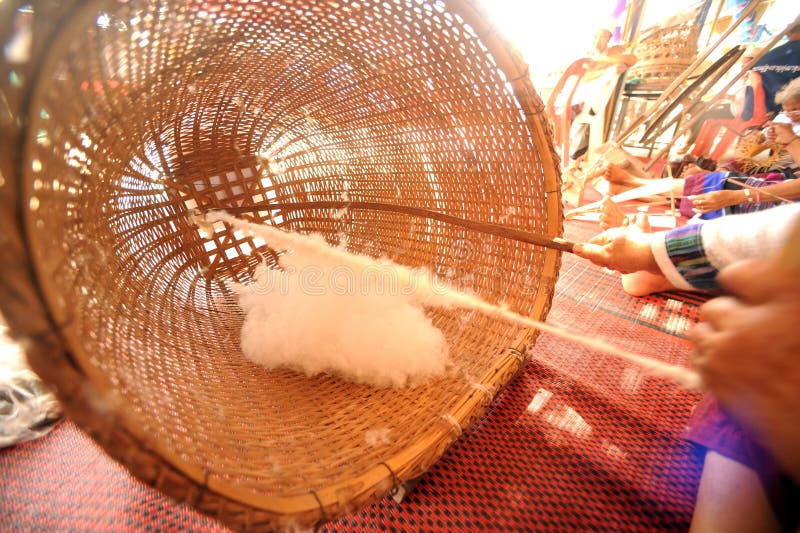 Minority Elder Woman Spinning Cotton with a Spinning Wheel. Stock Photo