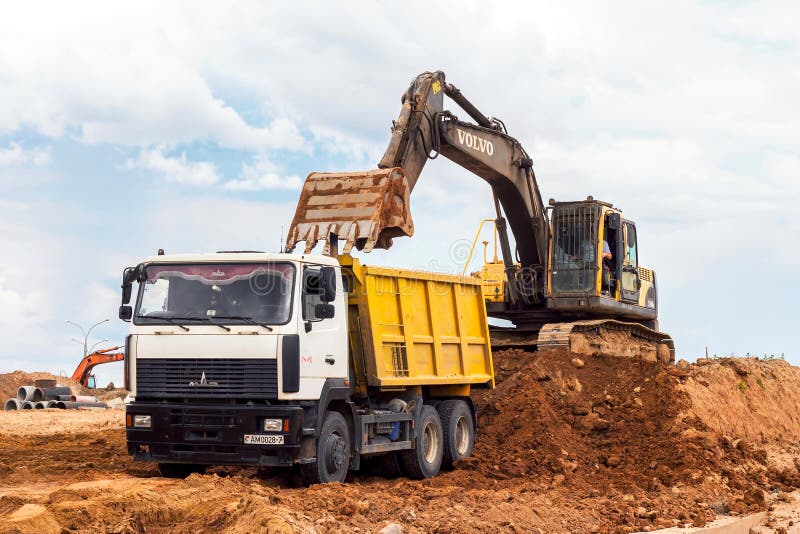 MINSK, BELARUS - July 2, 2021: Bright yellow heavy industrial excavator working on construction site in the city.