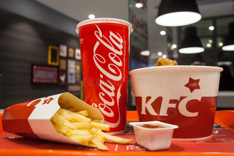Minsk, Bielorussia - 30 ottobre 2017: Pranzi dai canestri del pollo, le patate fritte, coca-cola e sauce un ristorante di KFC fotografia stock Minsk, Bielorussia - 30 ottobre 2017: Pranzi dai canestri del pollo, le patate fritte, coca-cola e sauce un ristorante di KFC fotografia stock