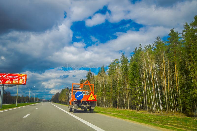 MINSK, WIT-RUSLAND - MEI 01, 2018: Ooutdoormening van zware machines in de weg aan de luchthaven van Minsk tegen dramatisch stock foto MINSK, WIT-RUSLAND - MEI 01, 2018: Ooutdoormening van zware machines in de weg aan de luchthaven van Minsk tegen dramatisch stock foto