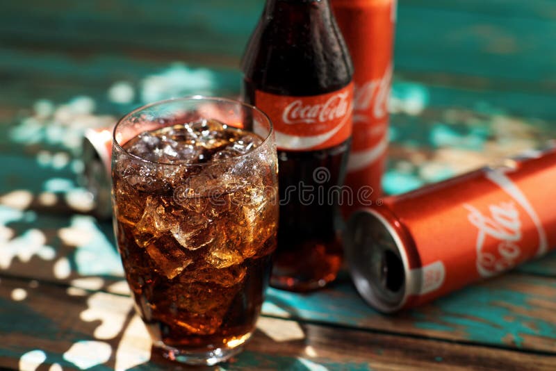 MINSK, 25 WITRUSSISCH-AUGUSTUS, 2016 Kan en een glas van bevroren Coca-Cola op een houten lijst stock afbeelding MINSK, 25 WITRUSSISCH-AUGUSTUS, 2016 Kan en een glas van bevroren Coca-Cola op een houten lijst stock afbeelding