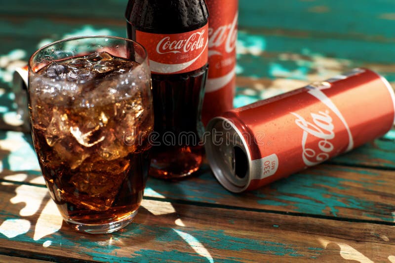 MINSK, 25 WITRUSSISCH-AUGUSTUS, 2016 Kan en een glas van bevroren Coca-Cola op een houten lijst royalty-vrije stock afbeeldingen MINSK, 25 WITRUSSISCH-AUGUSTUS, 2016 Kan en een glas van bevroren Coca-Cola op een houten lijst royalty-vrije stock afbeeldingen