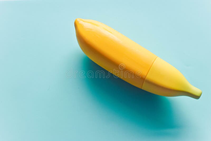 Minsta begrepp med kruset för bananhandcrem på den blåa bakgrunden royaltyfria bilder Minsta begrepp med kruset för bananhandcrem på den blåa bakgrunden royaltyfria bilder