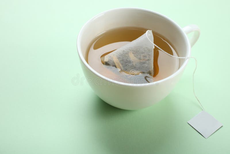 Mint tea bag in a cup stock photo. Image of color, dishes 111563024