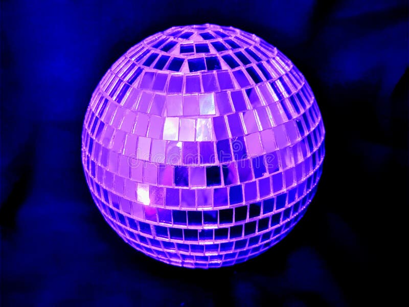 Mirror disco ball with pink lighting on a black  background at night. Disco violet light stock images, royalty-free photos and pictures