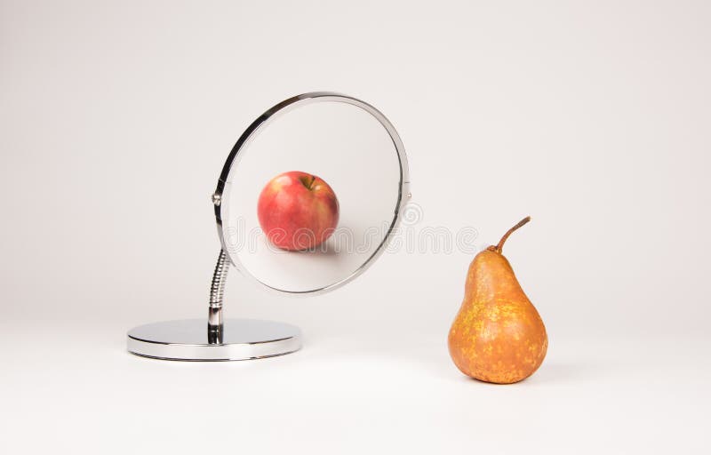 Mirror reflecting apple and pear