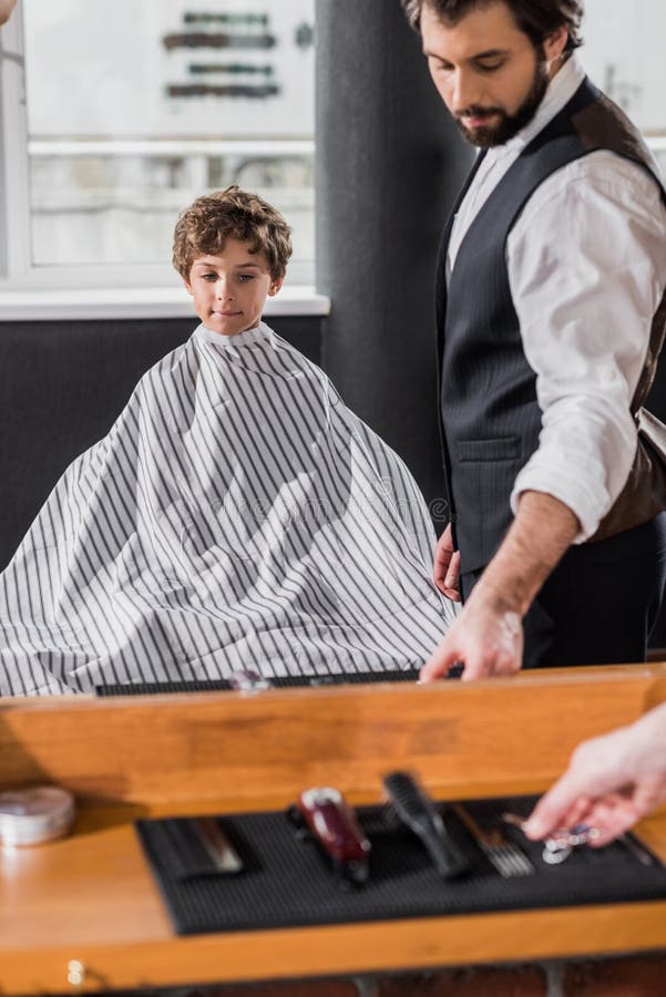 Mirror Reflection of Barber Preparing To Cut Hair of Stock Photo